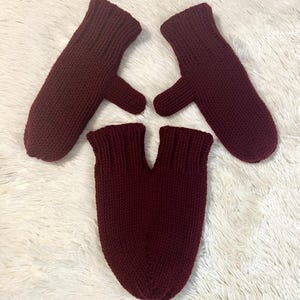 Può includere: Un paio di guanti di lana color granata e un cappello di lana color granata abbinato.