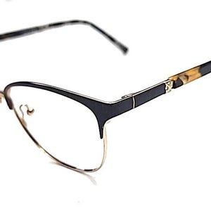 May include: Eyeglasses featuring a semi-rimless design with a thin gold-tone metal frame on the lower half and a solid black upper brow bar. The temples transition from black to a brown and black tortoiseshell pattern at the tips.