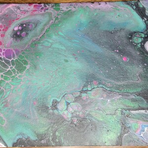 May include: Abstract acrylic pour painting on canvas. The artwork features a blend of colors, including teal, green, pink, purple, and black. The fluid art style creates a marbled effect with organic shapes and textures.