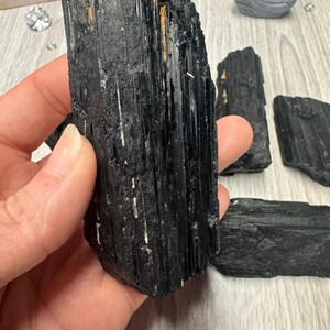 Puede incluir: Puntos de cristal de turmalina negra, tambi&eacute;n conocidos como Schorl, son una opci&oacute;n popular para la conexi&oacute;n a tierra y la protecci&oacute;n. Estos cristales son naturalmente negros con una textura estriada.