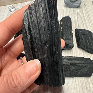 Puede incluir: Puntos de cristal de turmalina negra, tambi&eacute;n conocidos como schorl, son una opci&oacute;n popular para la conexi&oacute;n a tierra y la protecci&oacute;n. Estos cristales son naturalmente negros y tienen una textura estriada, casi como de madera.