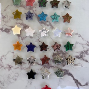 May include: A collection of 30 star-shaped polished stones in various colors and patterns, including green, red, blue, white, and brown.