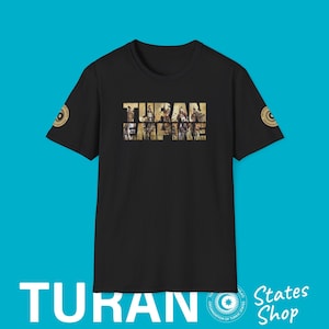 Puede incluir: Camiseta negra con las palabras "Turan Empire" impresas en blanco. Las palabras están formadas por un collage de imágenes. La camiseta tiene un pequeño círculo dorado con una estrella en las mangas izquierda y derecha.