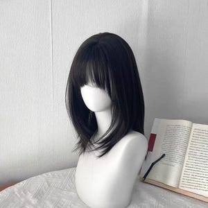 かわいい女の子らしいミディアムレングスのナチュラルウィッグ、毎日のエアバング、甘くてかわいいショートブラックウィッグ