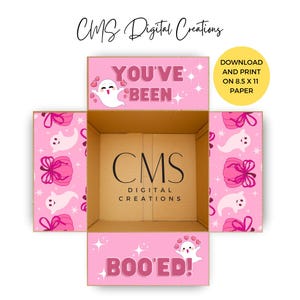 May include: A pink, open cardboard box with a Halloween theme. The box features the text "YOU'VE BEEN" and "BOO'ED!" along with ghost and gift graphics. The text "DOWNLOAD AND PRINT ON 8.5 X 11 PAPER" is also visible.