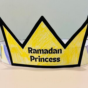 May include: A yellow paper crown with black outlines and the words "Ramadan Princess" written in black.
