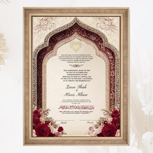 May include: A framed marriage certificate with an ornate design. The certificate features a burgundy and gold archway with floral accents. The names Zara Shah and Haris Khan are displayed, along with the date and location of the marriage.
