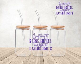 May include: Three clear glass tumblers with bamboo lids and clear straws. Each tumbler has a purple and white design that reads "I just want to drink coffee and listen to Taylor Swift".