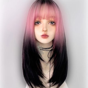 May include: A long, straight wig with pink and black ombre hair. The wig has a blunt cut fringe and is styled with a centre parting.