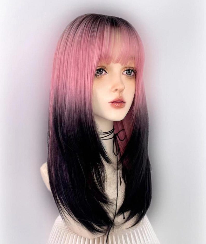 May include: A long, straight wig with pink and black ombre hair. The wig has bangs and is styled in a layered cut.