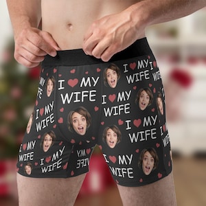 Könnte beinhalten: Schwarze Boxershorts mit einem sich wiederholenden Muster aus roten Herzen und dem Text "Ich liebe meine Frau". Das Muster enthält auch ein sich wiederholendes Bild eines Frauen Gesichts.