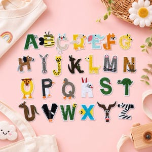 May include: A collection of twenty-six embroidered alphabet patches, each featuring a unique animal design integrated into the letter shape. The patches are arranged in rows on a pink surface, showcasing a variety of colors and creatures from A to Z.