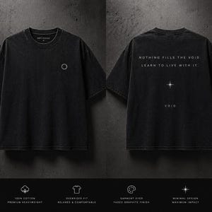 Könnte beinhalten: Schwarzes, übergroßes T-Shirt mit dem Text "NOTHING FILLS THE VOID. LEARN TO LIVE WITH IT." auf dem Rücken. Auf der Vorderseite befindet sich ein kleines kreisförmiges Design. Hergestellt aus 100% Baumwolle mit verwaschenem Graphit-Finish. Minimales Design für maximale Wirkung.