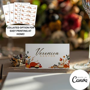 May include: White place cards with the name "Veronica Santos" in elegant script, adorned with fall-themed illustrations of pumpkins, food, and foliage. The image also shows a collated option for easy printing at home.