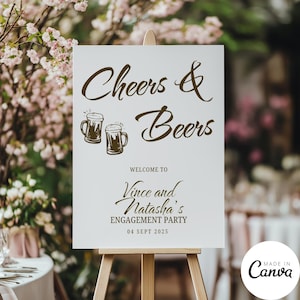 Op de afbeelding: Een wit bord op een houten ezel met de woorden "Cheers & Beers" in bruin script. Daaronder staat "Welcome to Vince and Natasha's Engagement Party 04 Sept 2025". Twee bierpullen zijn afgebeeld.