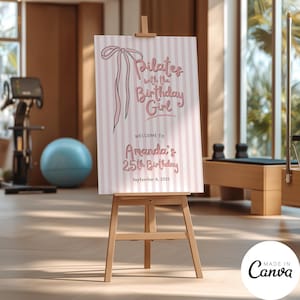 Puede incluir: Un caballete de madera muestra un letrero con el texto "Pilates with the Birthday Girl". El letrero tiene un fondo a rayas rosas y blancas y una ilustración de lazo rosa. El texto dice "Welcome to Amanda's 25th Birthday, September 6, 2025."