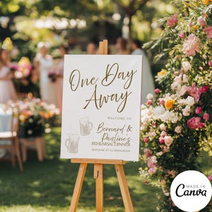 May include: A white sign on a wooden easel with the text "One Day Away" in elegant script. Below, it reads "Welcome to Bernard & Pauline's Rehearsal Dinner" with beer mug illustrations. The sign is set outdoors with floral decorations.