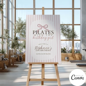 May include: A light pink and white striped Pilates birthday sign on a wooden easel. The sign reads "PILATES with the birthday girl" and welcomes guests to Stephanie's 21st birthday. The sign is in a gym setting.