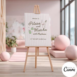 May include: A light pink and white striped welcome sign on a wooden easel. The sign features the text "Welcome to Pilates and Matcha with Stephanie" and "25th Birthday Celebration," along with illustrations of two green matcha drinks and legs.