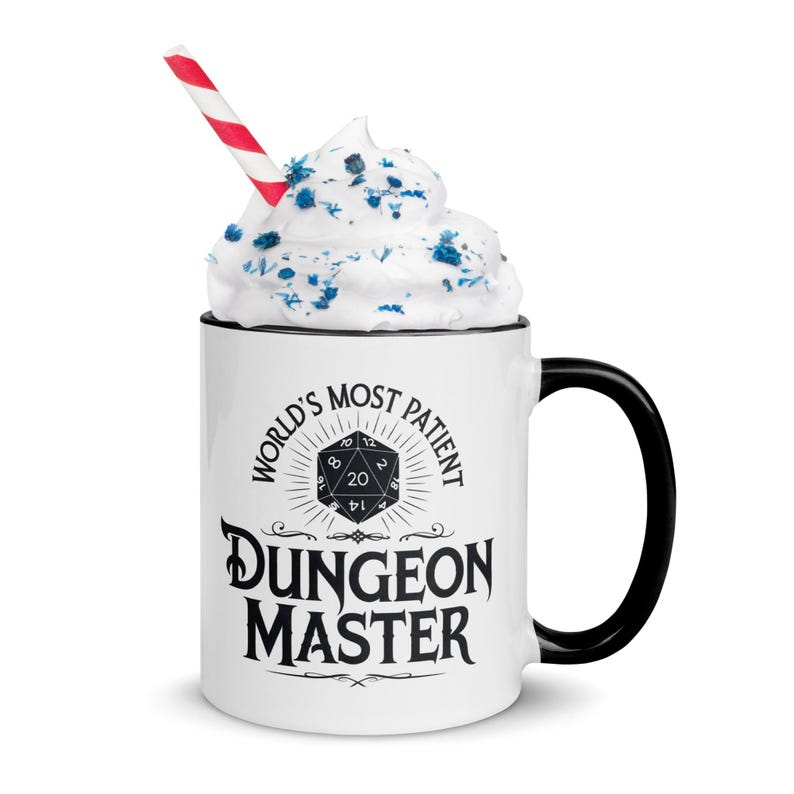 May include: White ceramic mug with a black handle. The mug has a black and white graphic that says "World's Most Patient Dungeon Master" with a 20-sided die in the center.