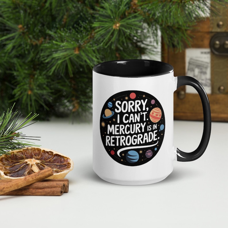 Peut inclure: Une tasse en c&eacute;ramique blanche avec un bord et une poign&eacute;e noirs. La tasse pr&eacute;sente un cercle noir avec des plan&egrave;tes color&eacute;es et le texte "D&eacute;sol&eacute;, je ne peux pas. Mercure est r&eacute;trograde."