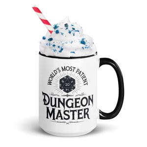 May include: White ceramic mug with a black handle and rim. The mug has a black and white design that says "World's Most Patient Dungeon Master" with a black and white 20-sided die graphic.