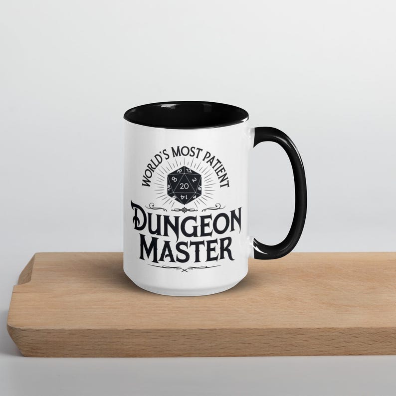 May include: White ceramic mug with a black rim and handle. The mug features a black and white graphic of a twenty-sided die with the text "World's Most Patient Dungeon Master".