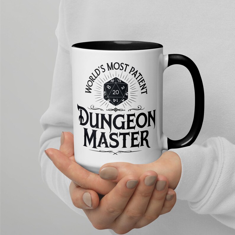 May include: White ceramic mug with a black handle and black rim. The mug has a black and white graphic of a twenty-sided die with the text "World's Most Patient Dungeon Master".