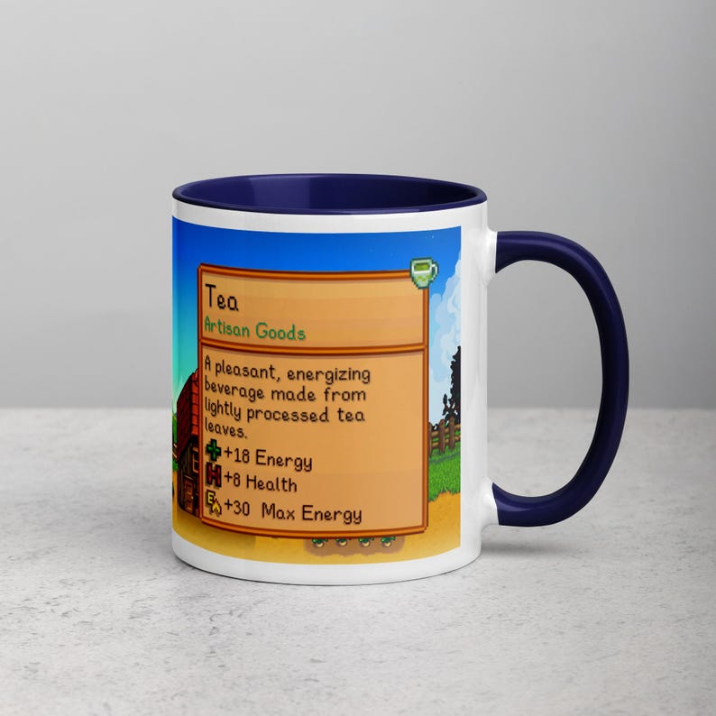 May include: A white ceramic mug with a blue interior and handle. The mug features a colorful graphic with the word "Tea" and text describing the beverage's properties. The mug is a perfect gift for tea lovers.