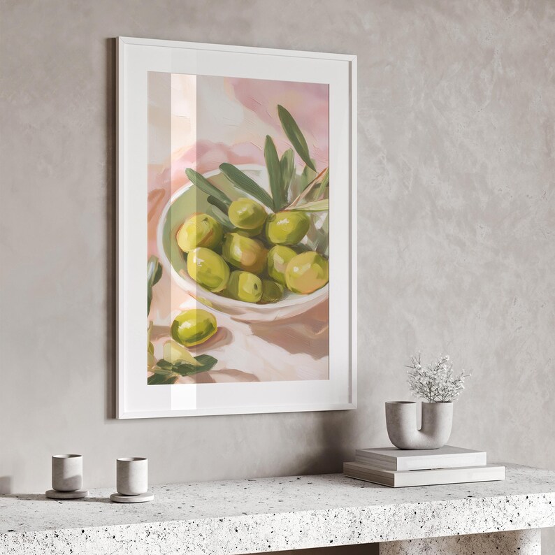 May include: A framed art print featuring a still life of green olives in a white and green bowl, with olive branches. The artwork is set against a soft pink and white background, creating a serene and natural aesthetic.