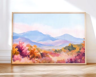 May include: A framed landscape painting featuring a mountain range under a light blue sky with pink clouds. The foreground displays colorful foliage in shades of orange, pink, and green. The artwork is displayed on a wooden floor.