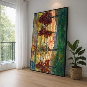 May include: Large framed artwork depicting a colourful abstract landscape with trees. The painting has a black frame and is leaning against a white wall. The artwork's colour palette includes red, yellow, green, and blue.