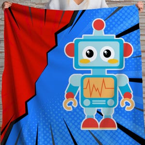 Puede incluir: Una colorida manta con un diseño de robot de dibujos animados. El robot es azul claro con detalles rojos, un cofre amarillo y grandes ojos negros. El fondo es azul con un diseño de estilo cómic y una sección roja a la izquierda.