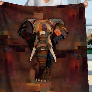 May include: A large, rectangular blanket featuring a mosaic-style elephant design. The elephant is composed of various textured patches in shades of brown, orange, and blue. The background has a geometric pattern in similar earthy tones.