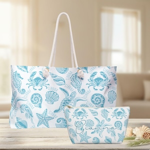 May include: A white tote bag and a matching zippered pouch featuring a repeating teal blue pattern of sea creatures including crabs, sea turtles, seahorses, starfish, and seashells, with the name GIANNA printed repeatedly across the fabric.