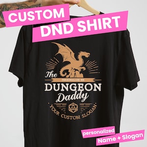 Könnte beinhalten: Schwarzes T-Shirt mit einem braunen Drachen-Motiv und dem Text "The Dungeon Daddy" mit einem personalisierbaren Namen und Slogan.