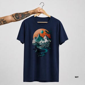 Navy blue unisex t-shirt with the DnD mountain adventure print on a hanger — vintage circular fantasy landscape design featuring D20, eagle, and pine forest on cotton tee labeled Navy