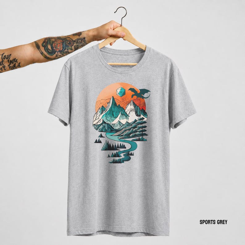 Sport Grey unisex t-shirt with the DnD adventure mountain design on a hanger — vintage circular landscape print with snowy peaks and soaring eagle, labeled Sport Grey