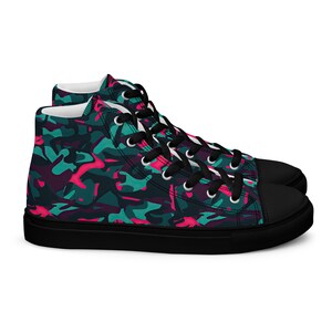Puede incluir: Zapatillas de lona de caña alta con suela negra y estampado de camuflaje en tonos turquesa, rosa y negro.