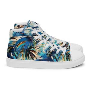 Könnte beinhalten: Weiße High-Top-Canvas-Sneaker mit einem tropischen Blatt-Muster in Blau, Grün und Gold.