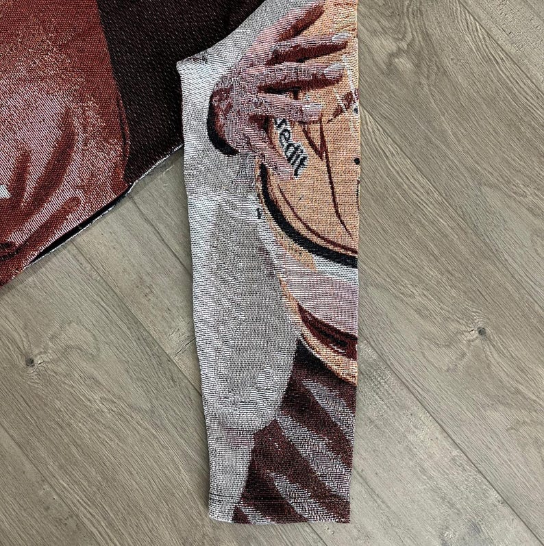 May include: A woven textile featuring a basketball design with the word "redit" visible. The textile has a mix of brown, beige, and gray tones, with a detailed texture. The image shows a close-up of the fabric, highlighting the intricate weave.