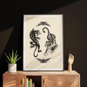 May include: A framed print with a black panther and a tiger facing each other in a circle. The animals are in a black and white illustration style with floral accents.
