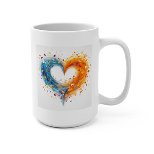 May include: White ceramic mug with a colorful abstract heart design. The heart is made up of swirling blue, orange, and yellow paint splatters.
