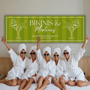Könnte beinhalten: Ein rechteckiges, grün-weiß gestreiftes Banner mit dem Text BIKINIS & Martinis, MELANIE'S BACHELORETTE, ST. PETE, FLORIDA und zwei weißen Strichzeichnungen einer Person im Bikini, die in einem großen Martiniglas sitzt.