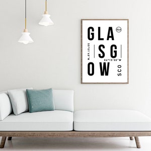 May include: Black and white typography print with the word "GLASGOW" in large letters. The print also includes the coordinates "55&deg;51&prime;40&Prime;N 04&deg;15&prime;00&Prime;W" and the abbreviations "GLA" and "SCO".