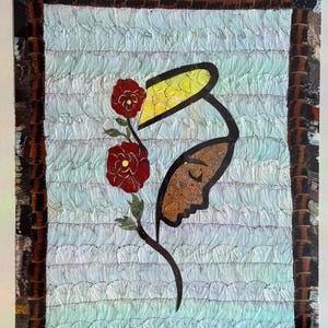 May include: Framed artwork featuring a stylized profile with a yellow headpiece and a flower. The artwork has a textured background with a light blue center and a dark frame. The flowers are red.