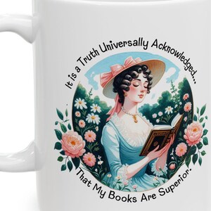 May include: White ceramic mug with a vintage illustration of a woman reading a book, surrounded by flowers. The mug has the text: "It is a Truth Universally Acknowledged... That My Books Are Superior."