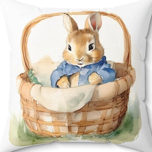 May include: A watercolor illustration of a brown rabbit wearing a blue jacket sitting in a wicker basket with green leaves.
