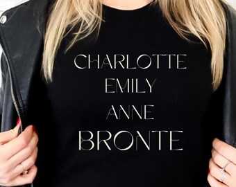 May include: Black t-shirt with white text that reads "CHARLOTTE EMILY ANNE BRONTE"