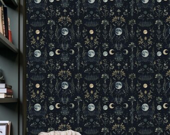 May include: Dark navy wallpaper featuring a repeating pattern of moons, crescent moons, and floral elements in gold and white. A leather armchair with a cream throw and pillow is in front of the wallpaper. A woven ottoman sits on the floor.